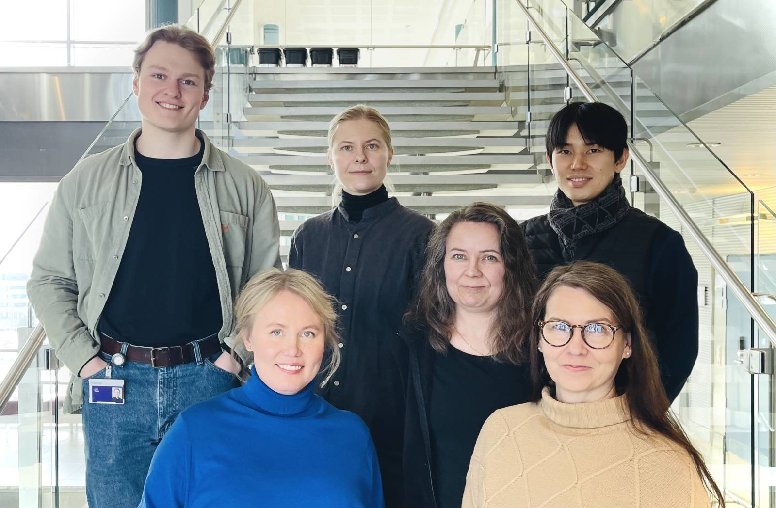 All project researchers standing at a staircase and smiling