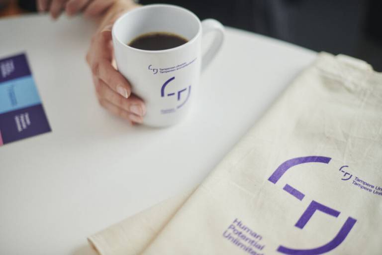 Kahvikuppi ja kangaskassi, joissa on TAMKin logo.