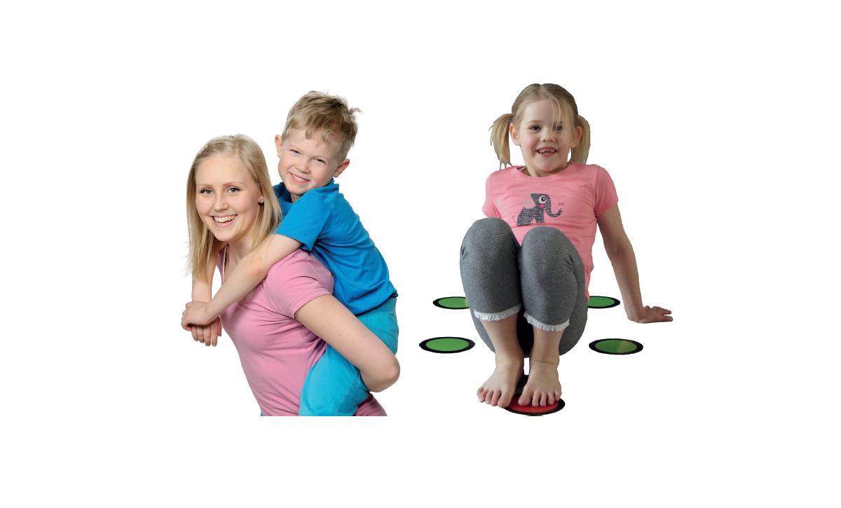 Nainen kantaa reppuselässä poikaa ja pieni tyttö leikkii.