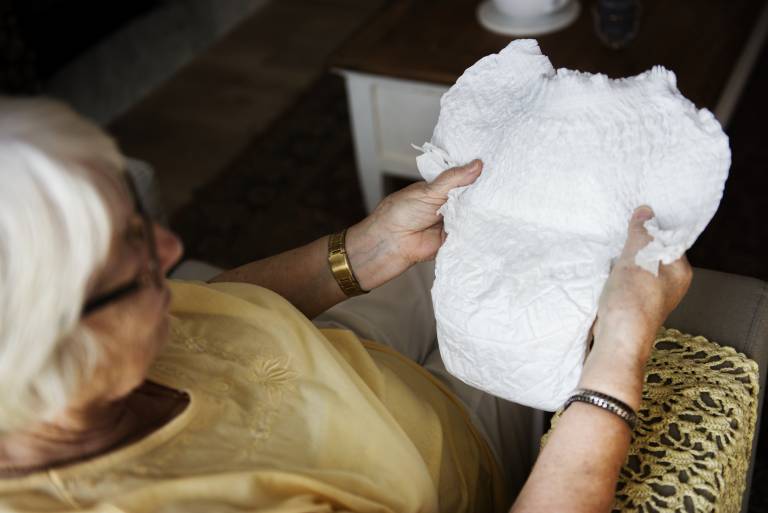 Senior woman looking at an incontinence pad