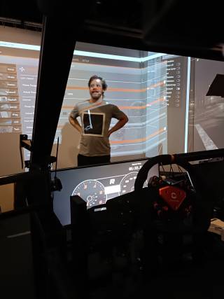 A man stands in the front of the driving simulator Carla.