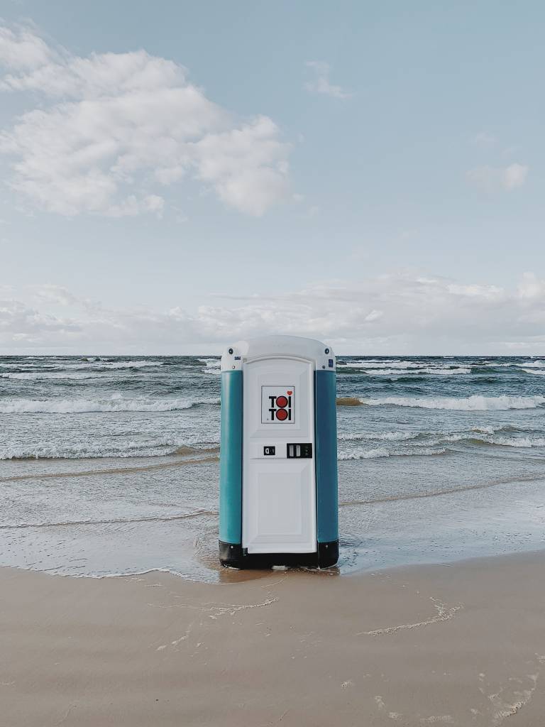 A lone porta-loo standing on a sea shore