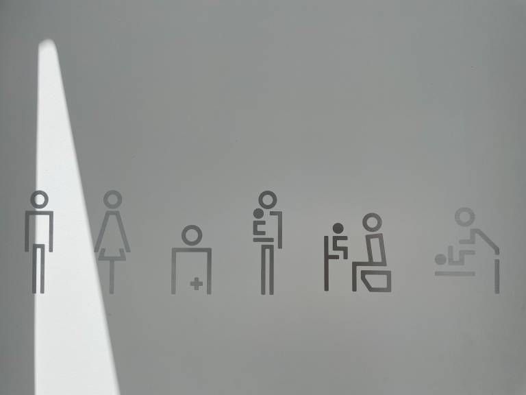 Kuusi erilaista WC:n käyttäjien tikku-ukkosymbolia seinällä