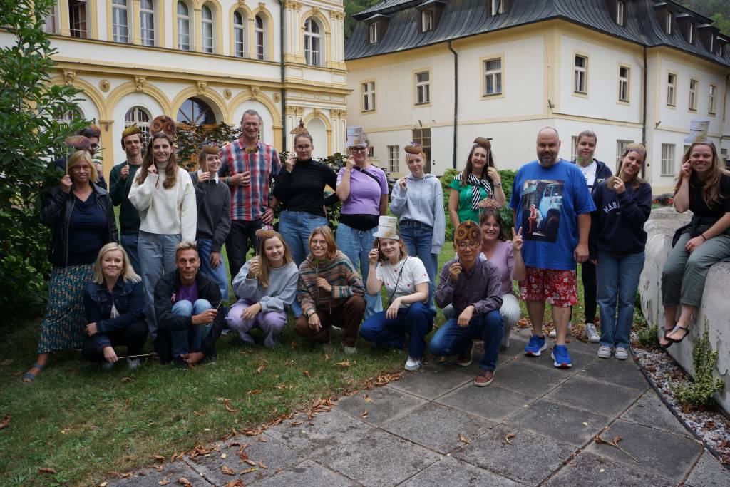 People in a group photo in outside setting in front of a building.