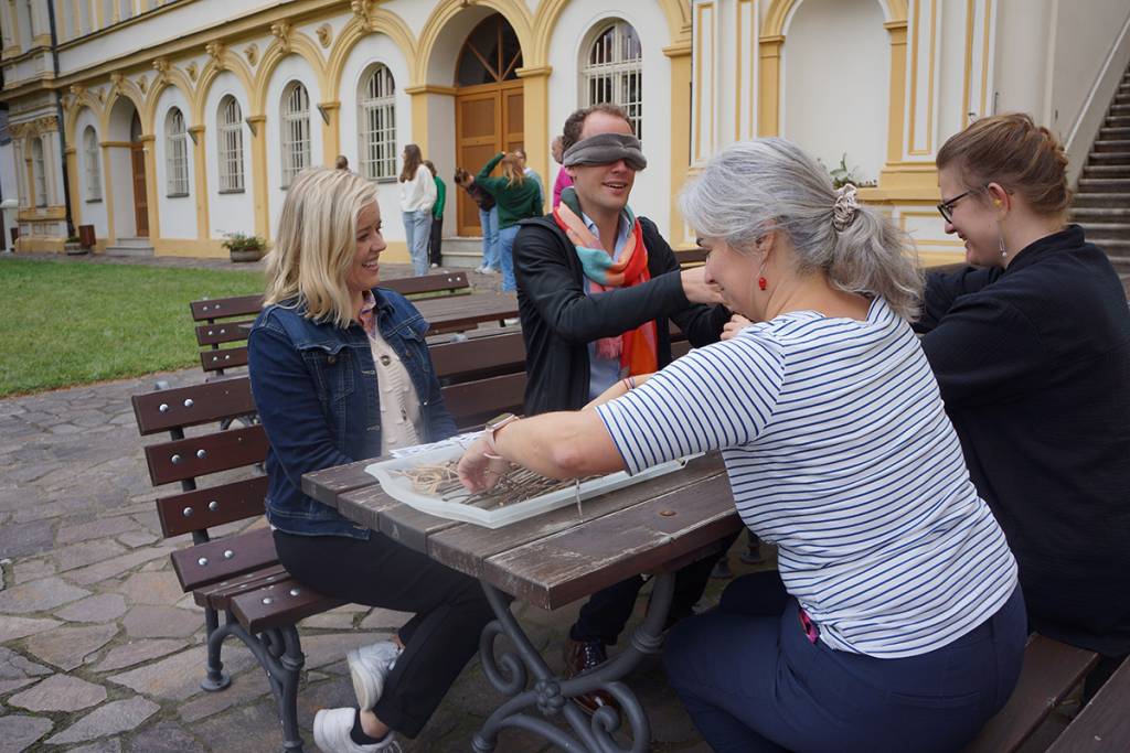 People playing a game outside gathered around the table.