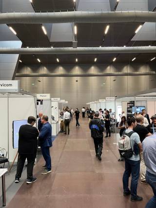 A hall full of trade show booths and people.