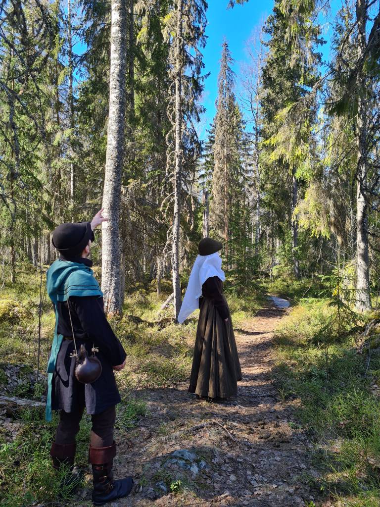 Medieval reenactors walking a path in a forest