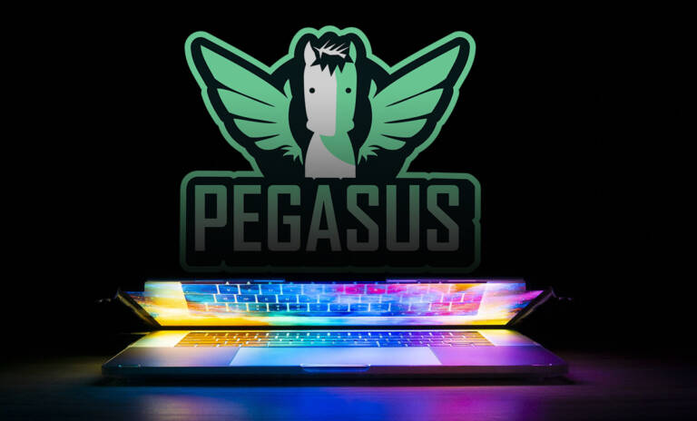 photo of a laptop in a dark space, with rainbow coloured lights reflecting from the screen. there is the pegasus logo behind the laptop in the dark.