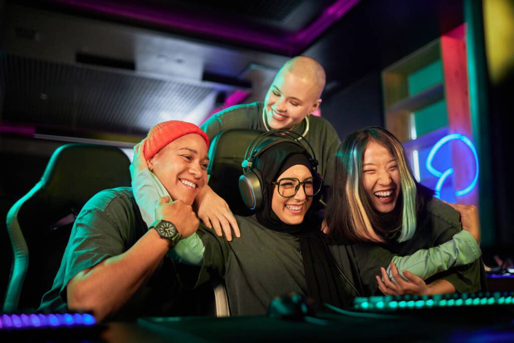 Diverse team of women gamers celebrating victory in cybersports competition and cheering